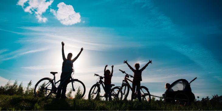 Silhouette of mother and kids riding bikes