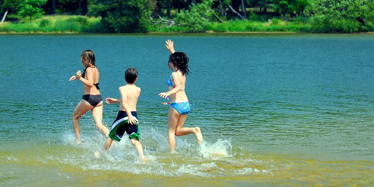 group of children running into the water - things to do in jindabyne with kids